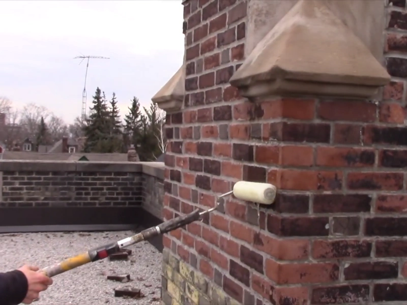 Waterproofing sealant spray applied to stone chimney stack