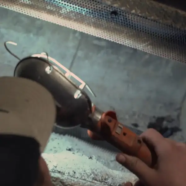 Technician checking damper and firebox using mirror and flashlight