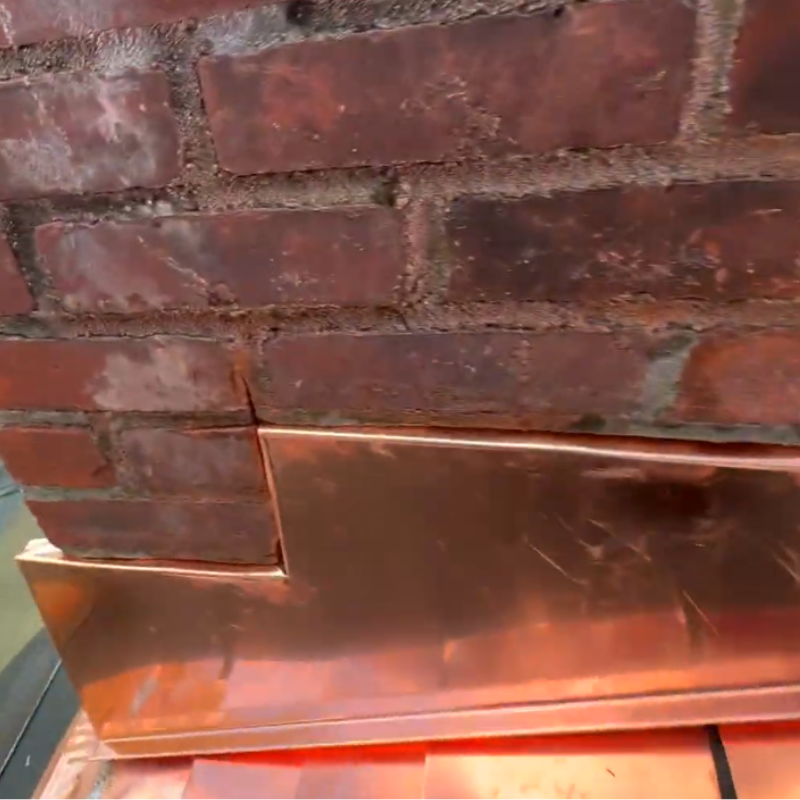 Metal chimney flashing installed at roofline