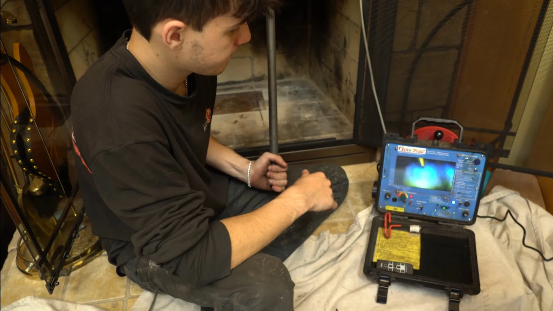 Certified chimney technician using video scanner camera on flue